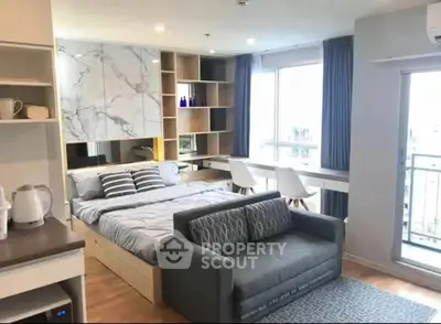 Modern studio apartment with stylish decor and large window view.