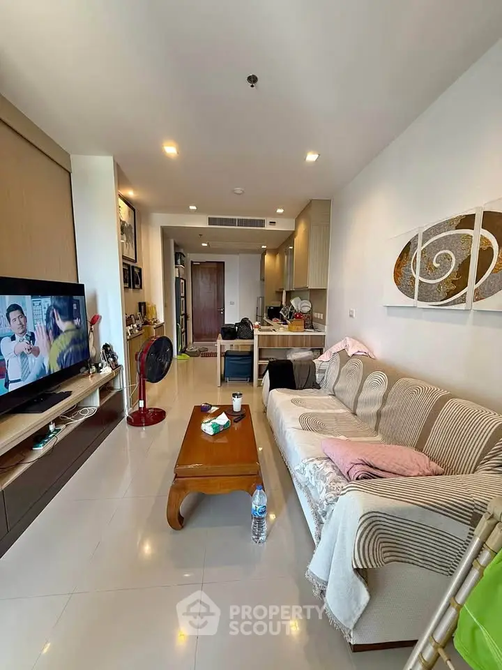 Modern living room with cozy sofa and open kitchen layout in stylish apartment.