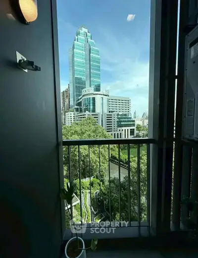 Stunning cityscape view from a modern balcony with lush greenery and iconic skyscrapers.