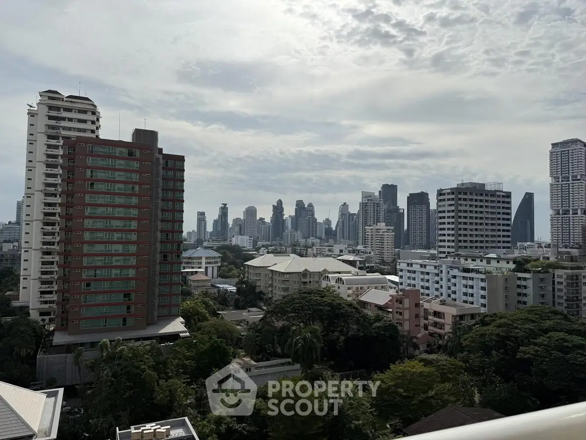 Stunning cityscape view from a high-rise balcony showcasing urban skyline and lush greenery.