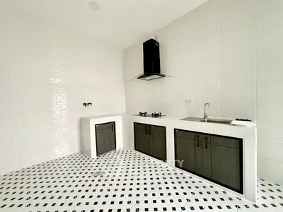 Modern kitchen with sleek black and white design featuring gas stove and ample storage.