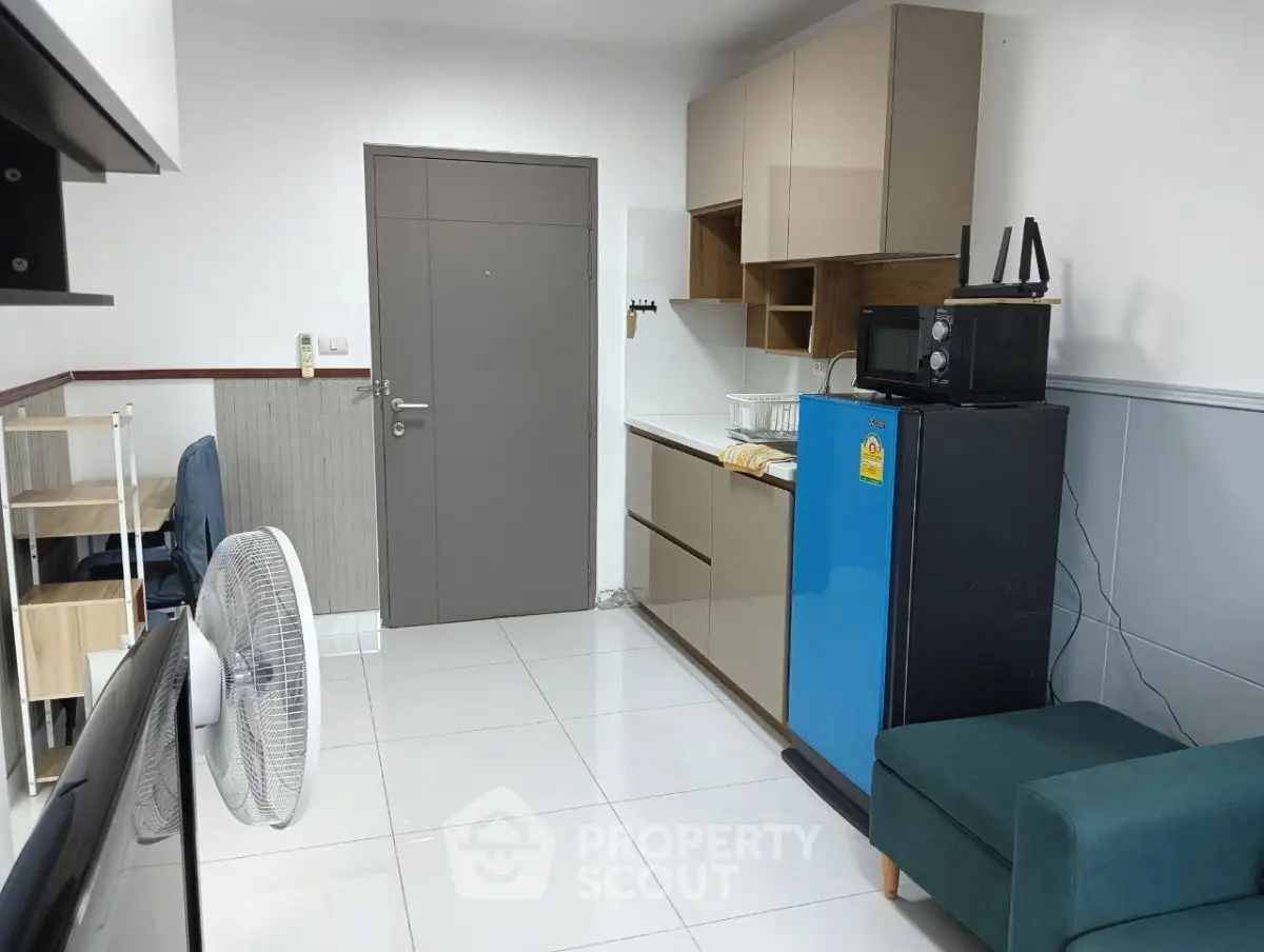 Compact modern kitchen with blue fridge and cozy seating area