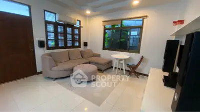 Cozy living room with modern sofa and entertainment setup, perfect for relaxation.