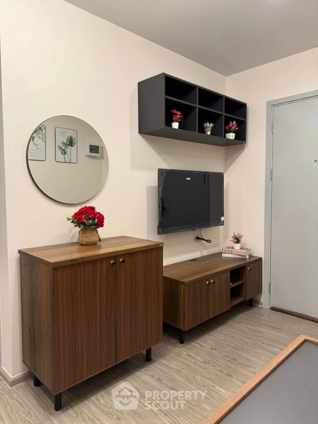 Modern living room with stylish wooden furniture and wall-mounted TV, perfect for cozy gatherings.