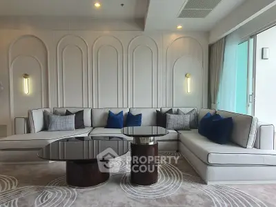 Luxurious modern living room with elegant sectional sofa and stylish coffee tables.