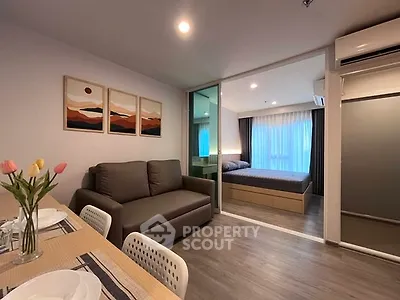 Modern open-plan living room with cozy sofa and stylish bedroom view