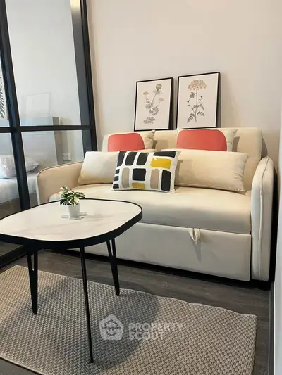 Modern living room with stylish sofa and decorative pillows, featuring a sleek coffee table and elegant wall art.
