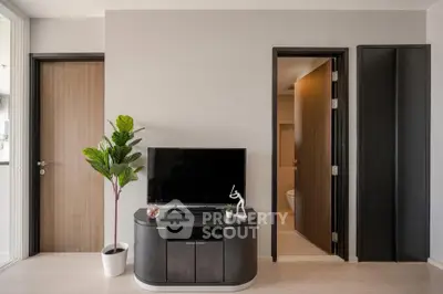 Modern living room with sleek TV stand and potted plant, showcasing minimalist design.