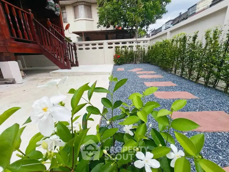 Charming garden with lush greenery and stepping stones in a serene residential setting.