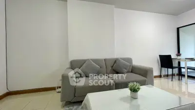 Modern living room with sleek gray sofa and elegant dining area