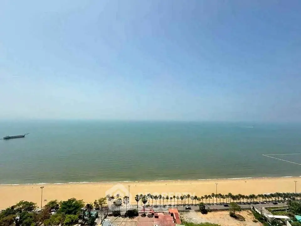Stunning beachfront view from high-rise apartment, showcasing serene ocean and sandy beach.