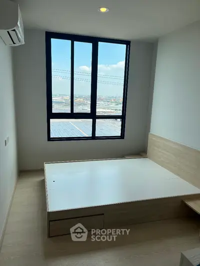Modern minimalist bedroom with large window and city view