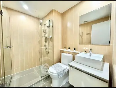Modern bathroom with glass shower and sleek fixtures in a contemporary home.