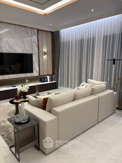 Luxurious modern living room with elegant decor and large TV, perfect for relaxation and entertainment.