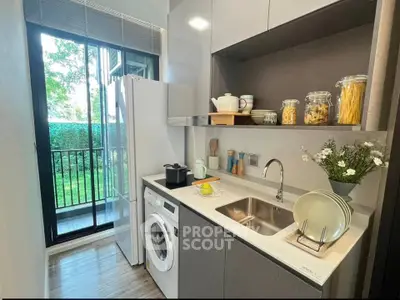 Modern kitchen with washing machine and balcony view, featuring sleek cabinetry and natural light.