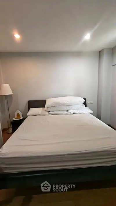 Cozy bedroom with modern decor and soft lighting, perfect for relaxation.