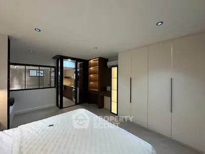 Spacious modern bedroom with built-in wardrobes and sleek lighting