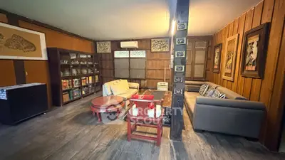 Charming rustic living room with wooden walls and cozy seating area.