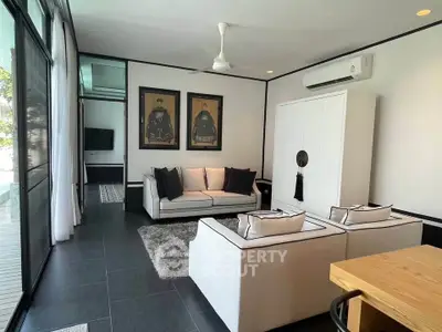 Stylish modern living room with elegant black and white decor and poolside view.