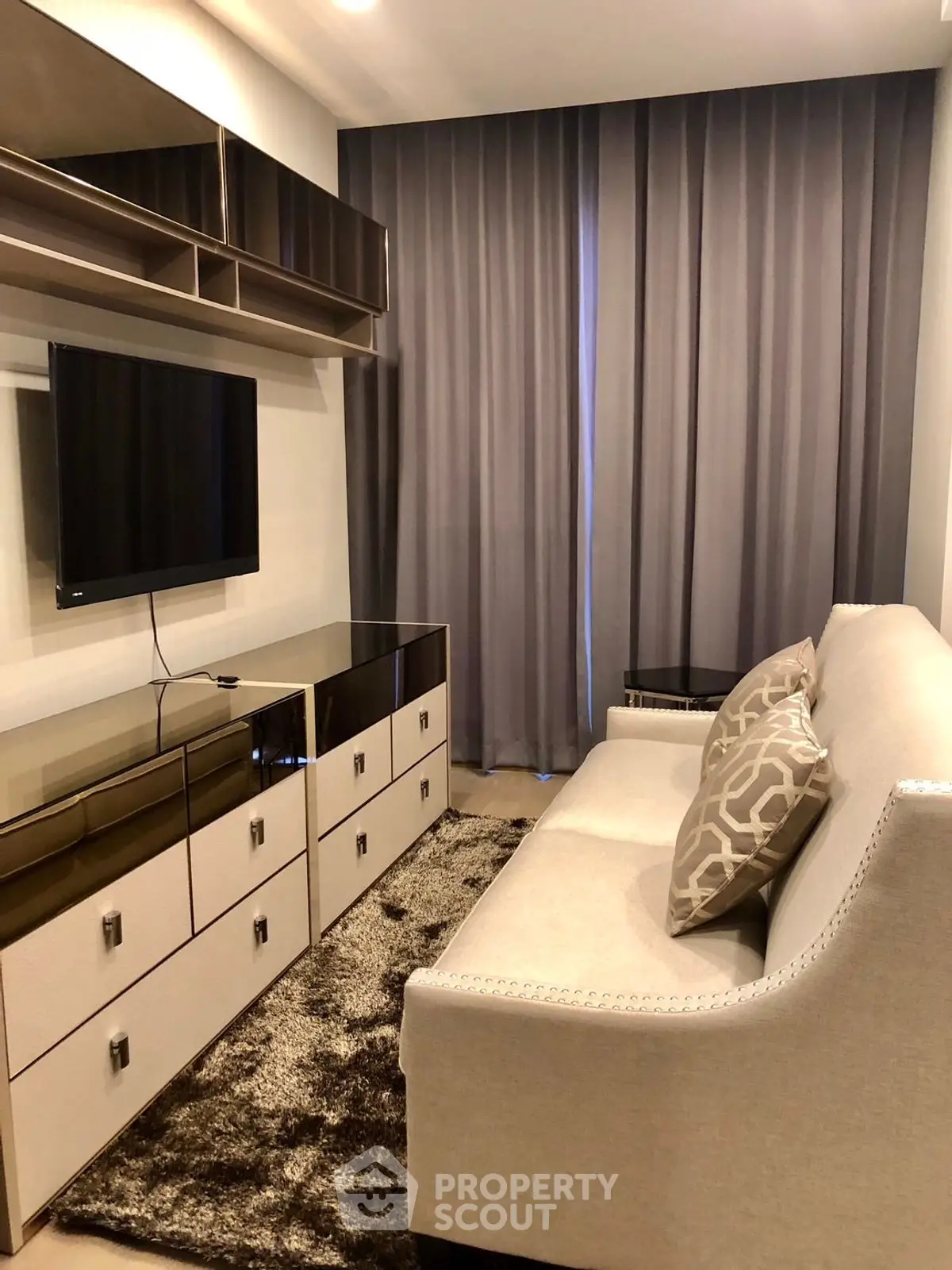 Stylish modern living room with elegant sofa and wall-mounted TV, perfect for cozy relaxation.