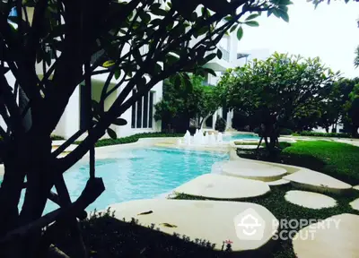 Luxurious garden view with serene pool and lush greenery in modern residential complex.