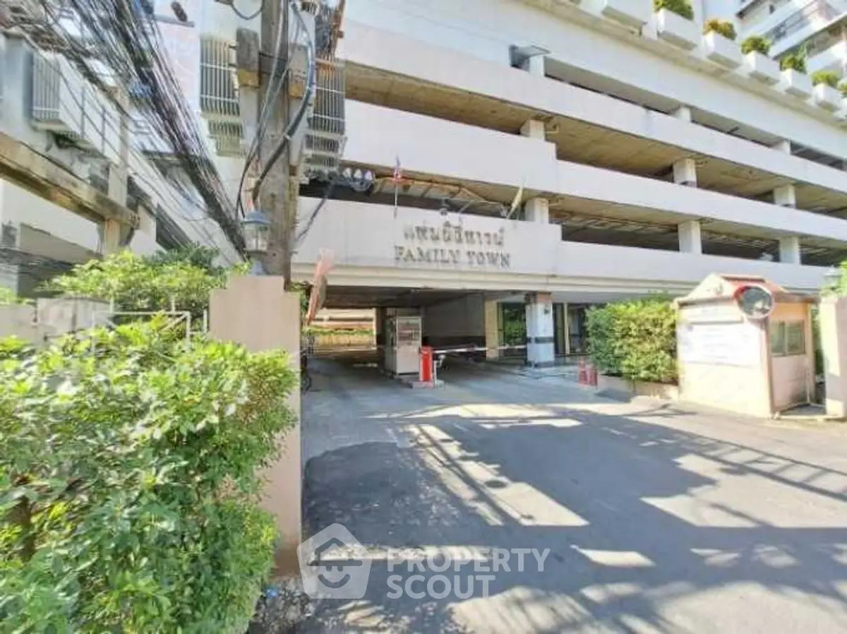 Spacious multi-level parking structure at Family Town with lush greenery and secure entrance.