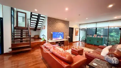 Spacious living room with modern decor and wooden staircase
