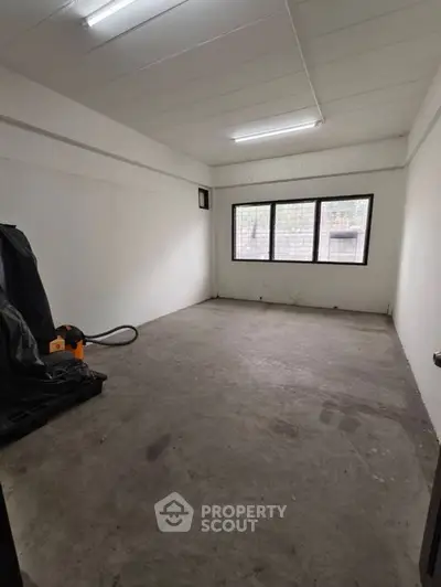 Spacious empty room with large windows and concrete floor, ideal for customization.