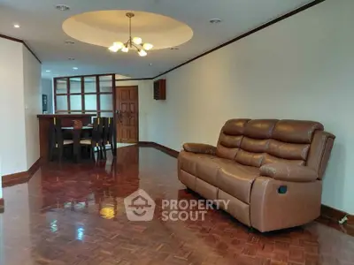 Spacious living room with elegant wooden flooring and cozy leather sofa, perfect for relaxation and entertaining.