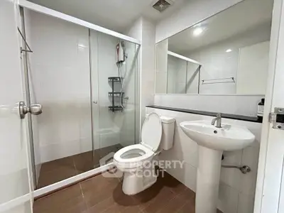 Modern bathroom with glass shower and sleek fixtures in a contemporary home.