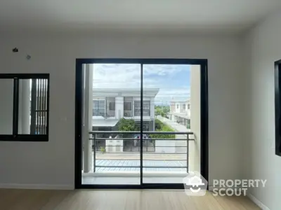 Bright and airy living space with large sliding glass doors opening to a spacious balcony, offering a seamless indoor-outdoor living experience.