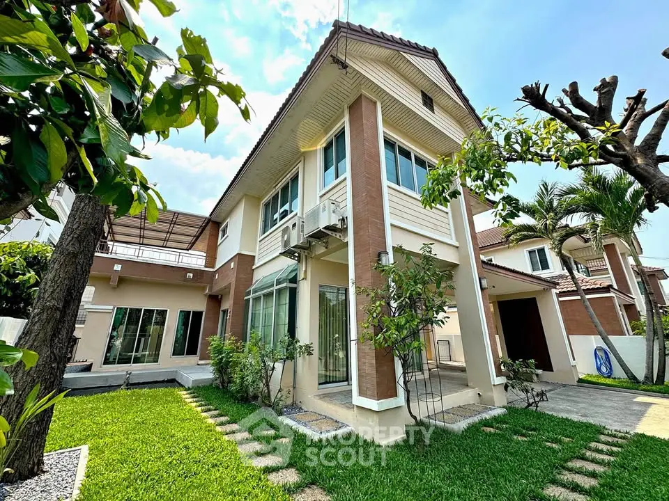Charming two-story house with lush garden and modern exterior design.