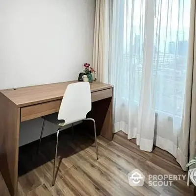 Minimalist study with a sleek wooden desk, modern chair, and floor-to-ceiling sheer curtains, offering a serene workspace.