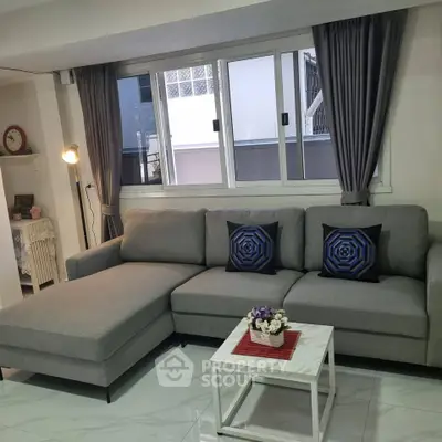 Modern living room with stylish gray sofa and chic decor