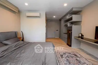 Modern bedroom with stylish decor and built-in shelving, featuring a cozy bed and elegant flooring.