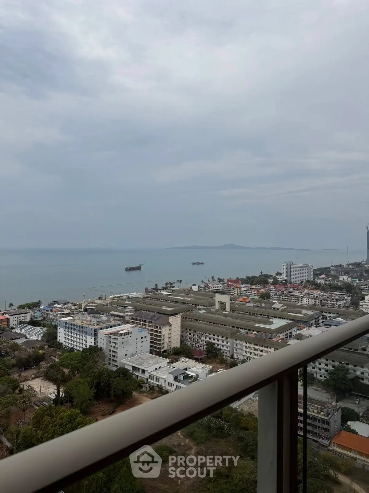 Stunning ocean view from high-rise balcony overlooking cityscape and coastline.