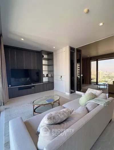 Modern living room with sleek design and city view, featuring a cozy sofa and large TV unit.