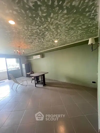 Spacious living room with unique ceiling design and balcony access, perfect for modern living.
