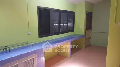Spacious room with vibrant green walls and blue tiled counter, ideal for creative use.