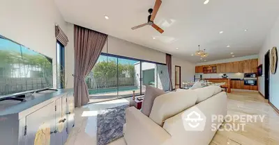 Spacious open-plan living room with pool view and modern kitchen