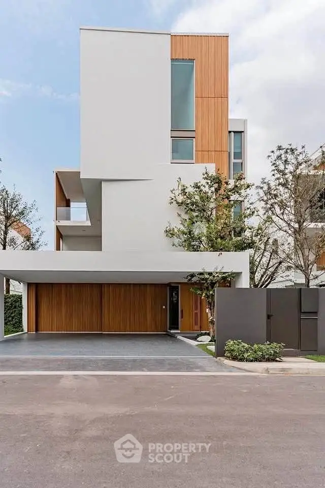 Modern architectural home with sleek design and wooden accents in a serene neighborhood.