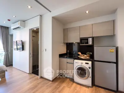 Modern compact kitchen with washing machine and fridge in stylish apartment