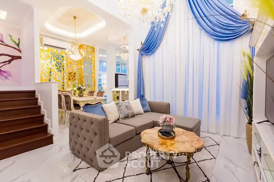 Luxurious living room with elegant decor, plush sofa, and stunning chandelier, perfect for sophisticated living.