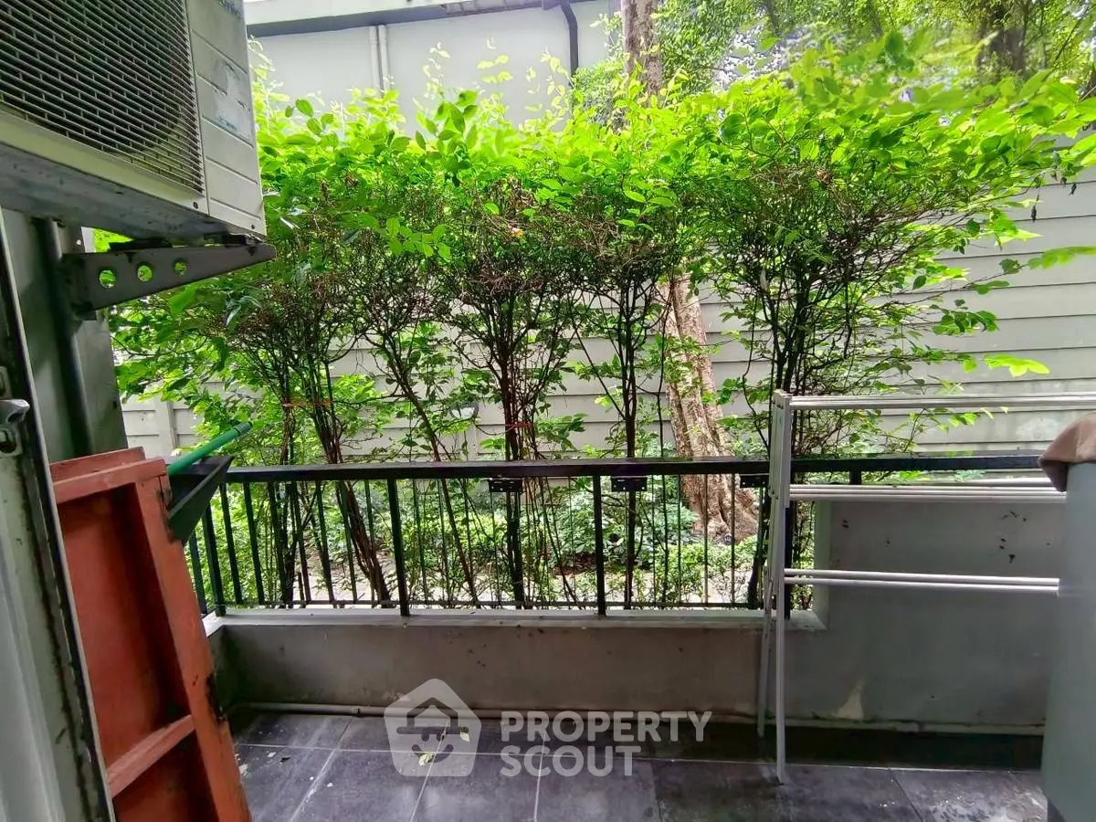 Charming balcony with lush greenery and modern railing, perfect for relaxation.
