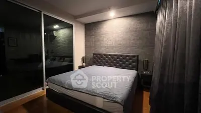 Modern bedroom with stylish decor and large mirror reflecting cozy ambiance.