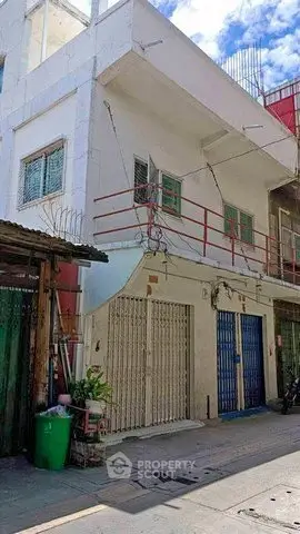 Charming urban building with gated entrance and balcony, ideal for residential or commercial use.