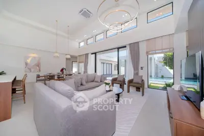 Luxurious open-plan living room with modern decor and pool view, perfect for entertaining.
