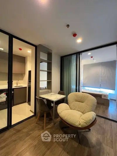 Modern open-plan living room with cozy seating and stylish kitchen area