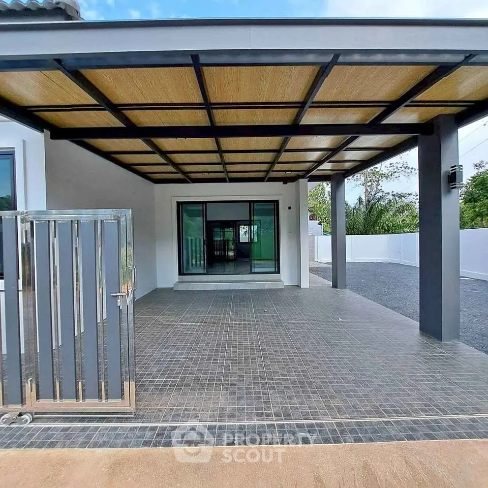 Modern house exterior with spacious covered patio and sleek gate design.