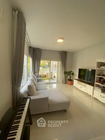 Spacious living room with modern decor and large windows offering natural light.